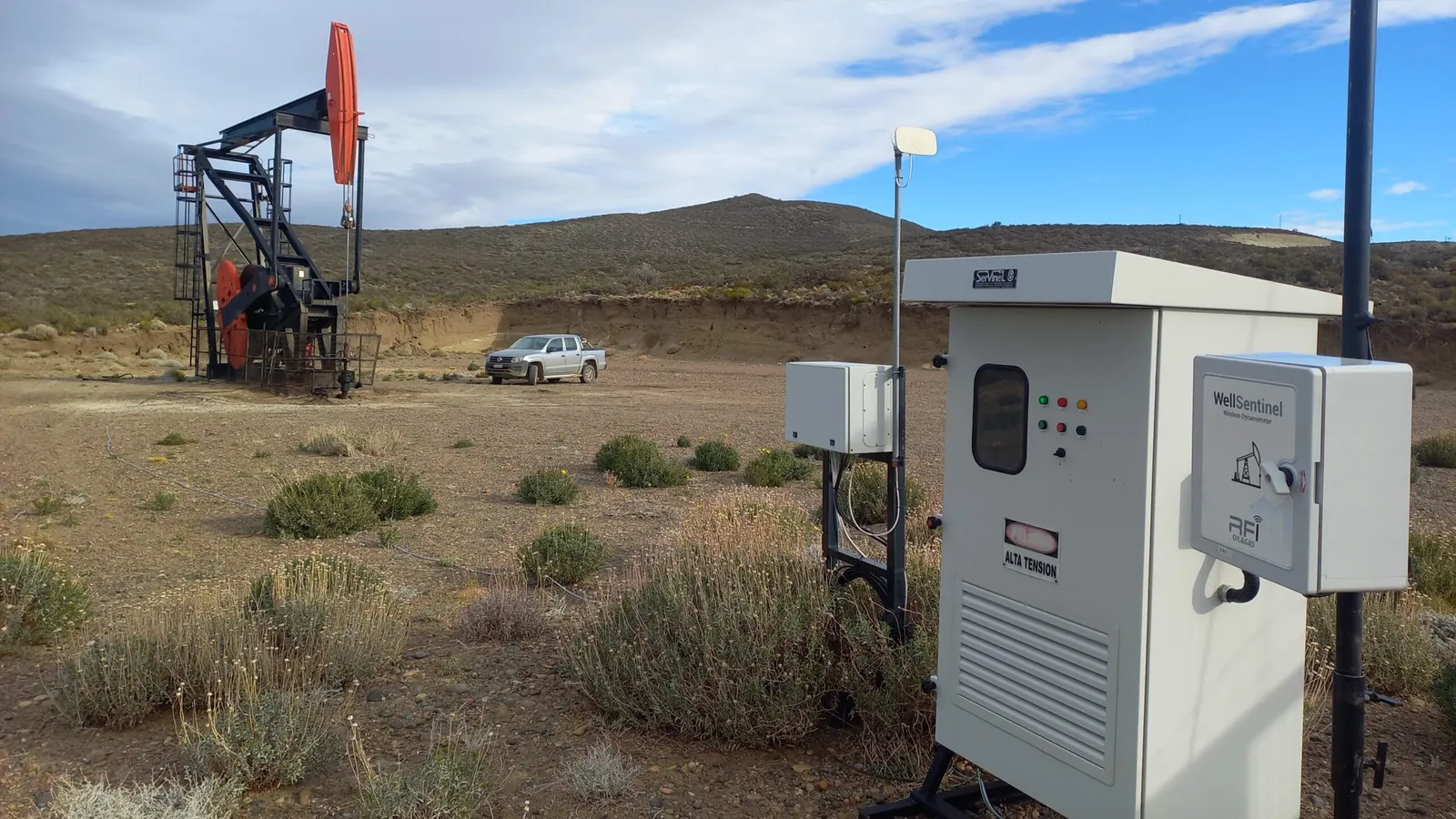 Gabinete electrónico instalado en yacimiento, con una unidad de bombeo al fondo